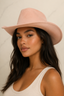 A woman wearing a dusty pink wide-brim fedora hat and a white ribbed tank top, photographed against a light beige marble background.