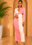 Woman in a pink and white dress standing against a beige wall with a plant to her left.