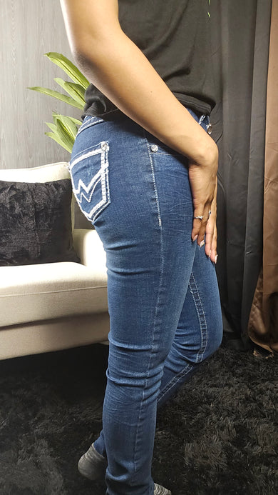 Person wearing blue jeans sitting on a chair with a blurred background