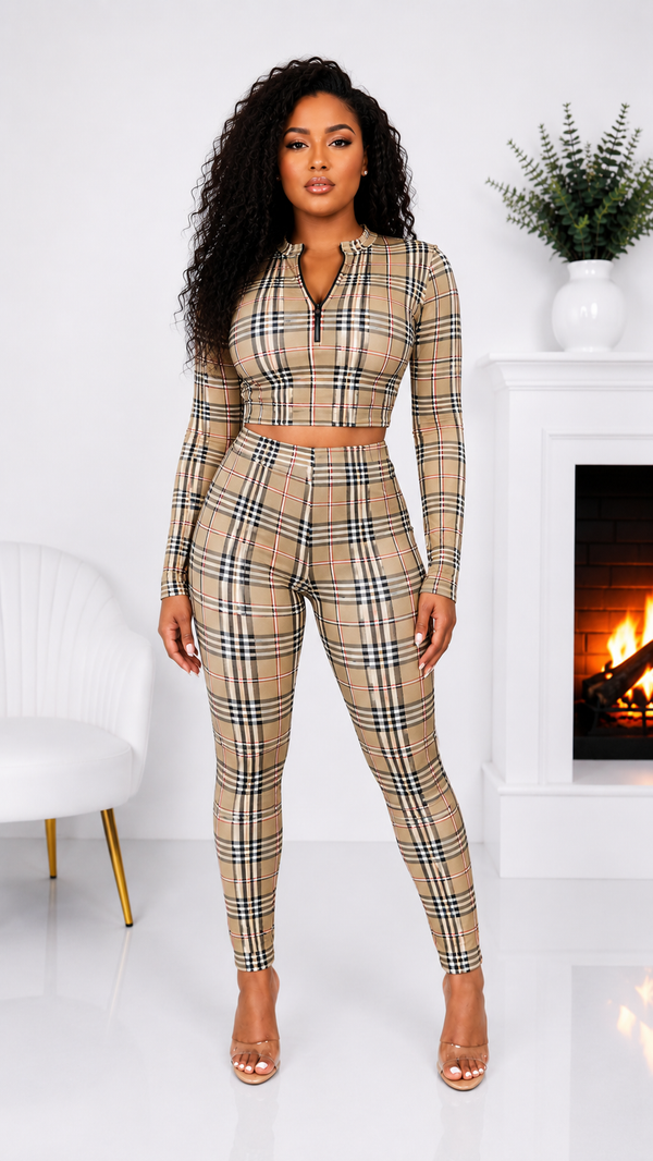 Woman wearing a plaid two-piece outfit in a room with a fireplace.