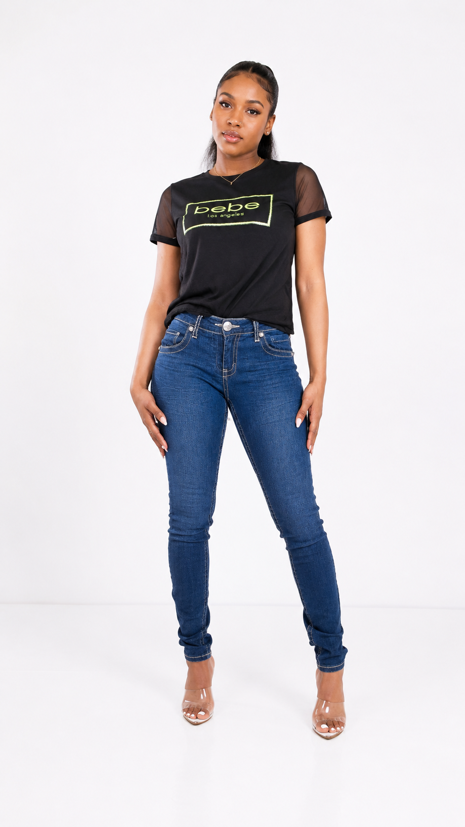 Woman wearing a black t-shirt with text and blue jeans on a white background