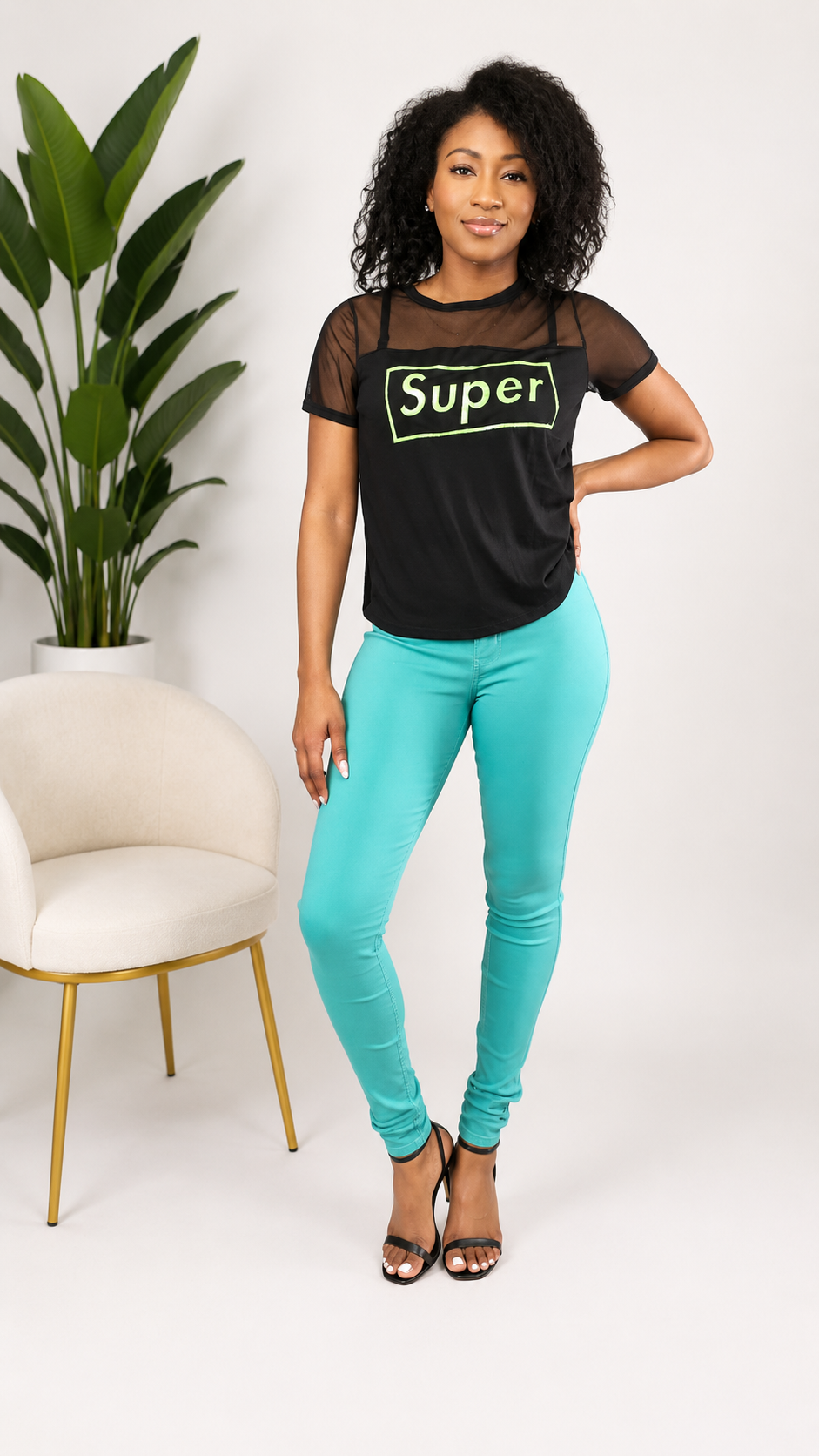 Woman wearing a black 'Super' t-shirt and teal leggings in a minimalistic setting.