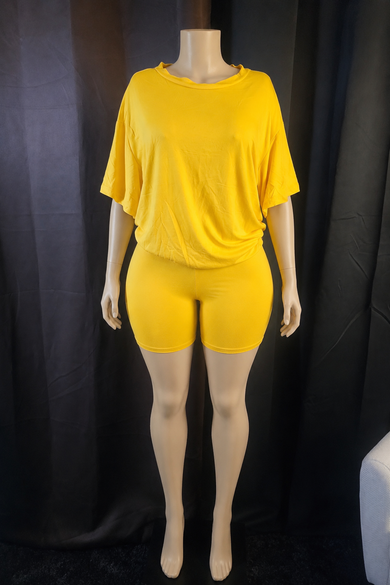A bright yellow two-piece lounge set consisting of a short-sleeve cropped t-shirt and matching high-waisted shorts, displayed on a mannequin against a black fabric backdrop.